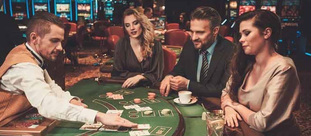 Krupier rozdaje karty, gracze przy stole blackjacka, eleganckie ubrania, filiżanka kawy, kasyno, hazard, strategia, skupienie